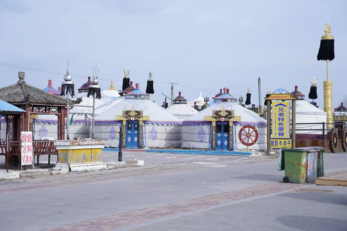 BookNoFees example image: Round yurts with ornate doors lining a paved path
