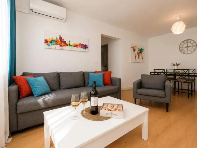 BookNoFees holiday home in Jerez De La Frontera – a living room with a sofa and a table with glasses of wine at Buleria, in Jerez de la Frontera