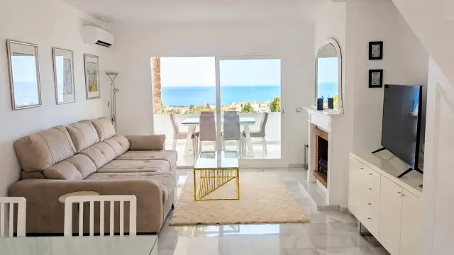 BookNoFees holiday home in Mijas – Living room with a sofa, television and sea-view terrace in Calahonda, Spain