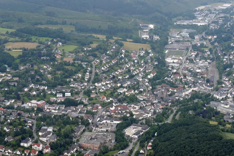 The town of Sundern from the air, houses along the Röhr valley between wooded hills