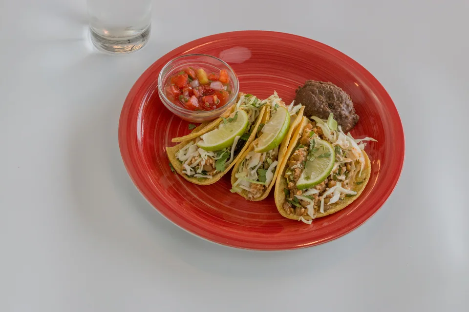 BookNoFees: Example photo: Three tacos topped with lime slices, with salsa on a red plate